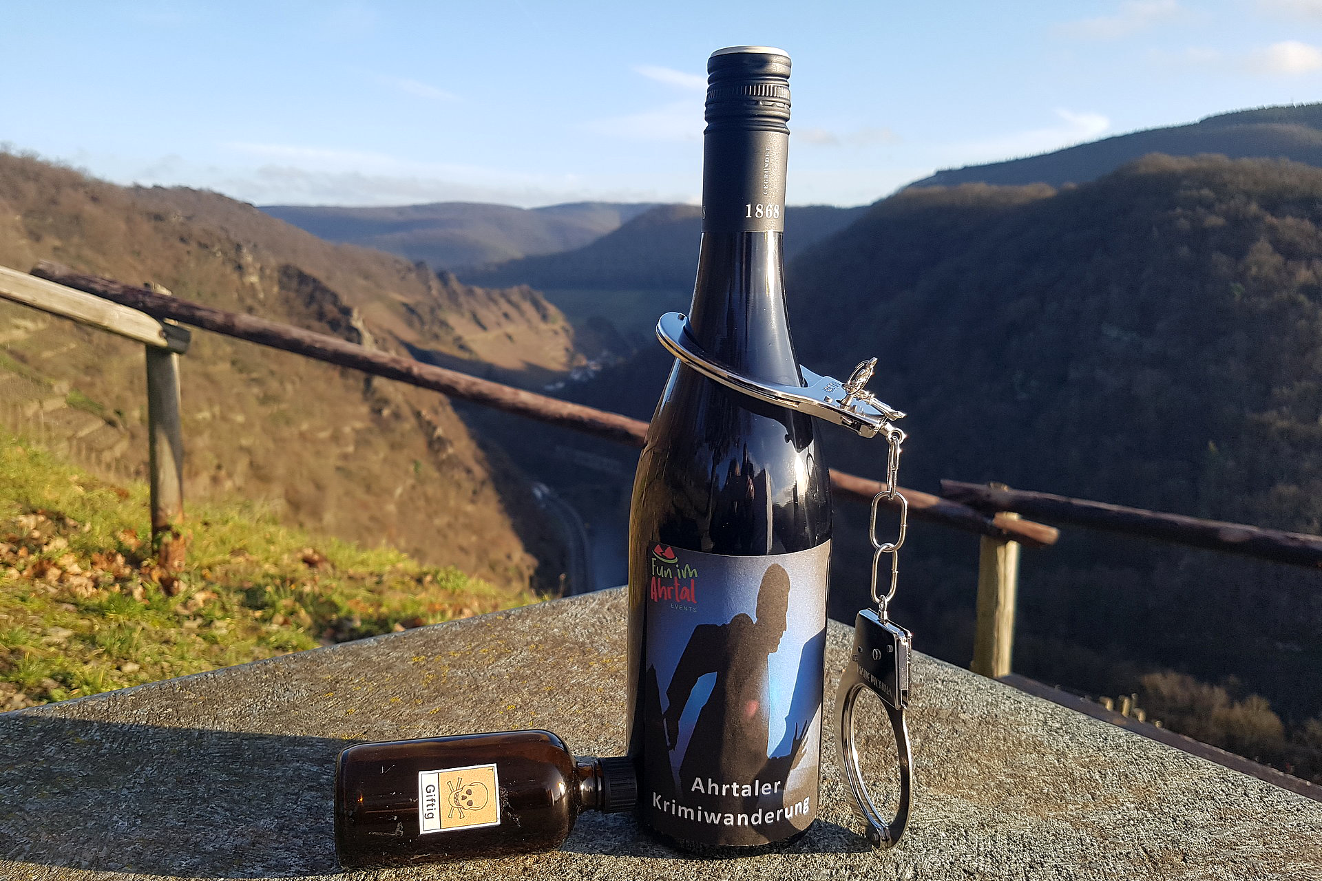 Krimiwanderung Flasche Ahrwein mit der Aufschrift „Krimiwanderung“ vor Ahrtalbergen.