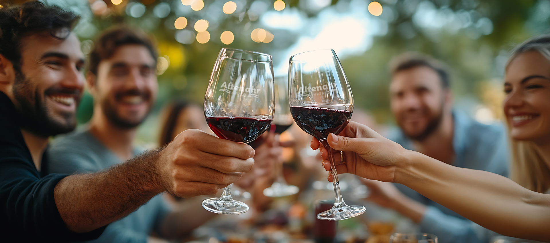 Header-Altenahr Fröhliche Menschen prosten sich mit einem Glas Rotwein zu.