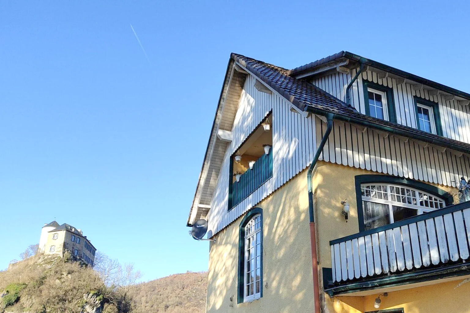 Aussenansicht Haus Hinkelstein mit Burg Kreuzberg im Hintergrund.
