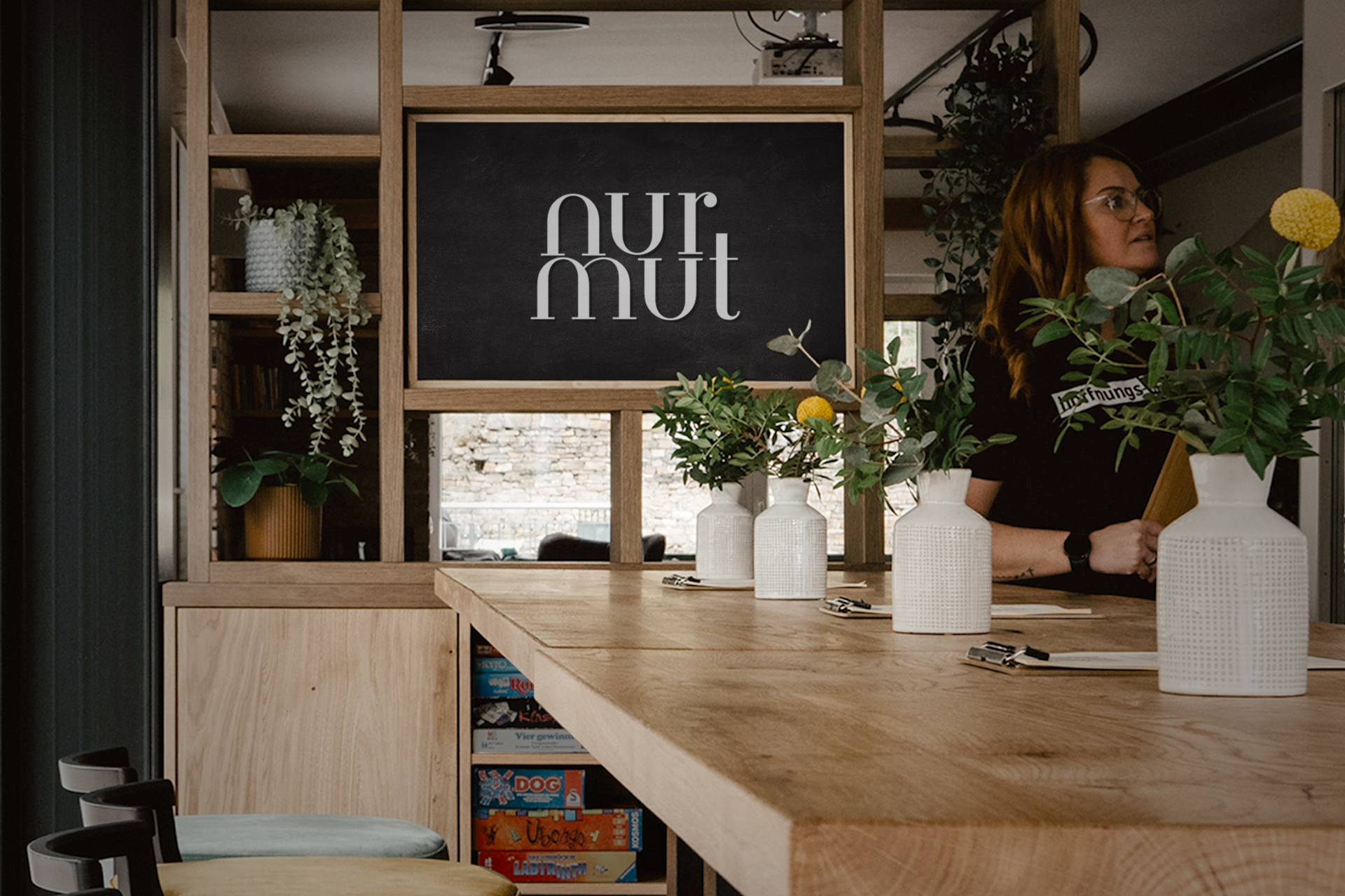 nurmut_1920x1280 Innenansicht Café „nur mut“ mit Holztisch, Stühlen und Pflanzen